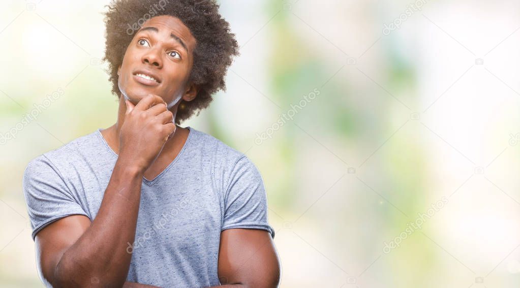 Afro american man over isolated background with hand on chin thinking about question, pensive expression. Smiling with thoughtful face. Doubt concept.