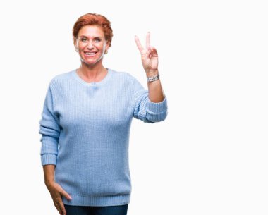 Mutlu yüz zafer işareti yaparken kameraya göz kırpıyor ile gülümseyen izole arka plan Atrractive üst düzey beyaz Kızıl saçlı kadın. İki numaralı.