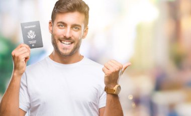 Amerika Birleşik Devletleri pasaport işaret ve başparmak kadar mutlu yüz gülümseyen tarafı ile gösteren izole arka plan üzerinde tutan genç yakışıklı adam