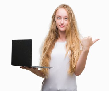 İşaret ve başparmak kadar mutlu yüz gülümseyen tarafı ile gösterilen bilgisayar dizüstü kullanan sarışın genç kadın