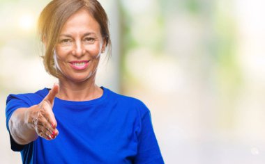 Orta yaş İspanyol kadın kıdemli dostu sunan el sıkışma tebrik ve davet edici olarak gülümseyen izole arka plan üzerinde. Başarılı iş.