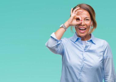 Orta yaş üst düzey İspanyol kadın gülümsüyor, parmakları ile mutlu yüz üzerinden seyir göz el ile ok jest yapıyor izole arka plan.