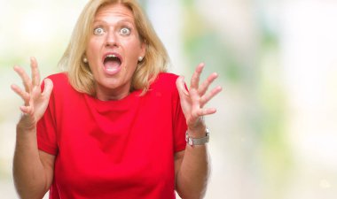 Orta yaş sarışın kadın izole arka plan çılgın ve kızgın bağırarak ve agresif ifade ve silah kaldırdı bağırıyor. Hayal kırıklığı kavramı.