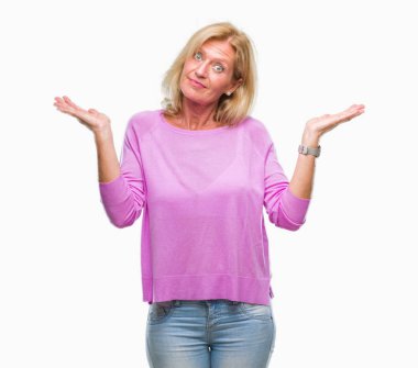 Orta yaş sarışın kadın izole arka plan clueless ve şaşkın bir ifadeyle kollar ve eller kaldırdı. Şüphe kavramı.