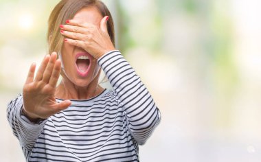 Orta yaş üst düzey İspanyol kadın izole elleriyle gözlerini kapsayan arka plan ve stop jest ile acı ve korku ifadesi. Utandım ve negatif kavramı.