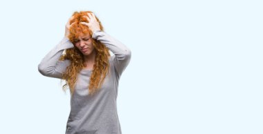 Genç Kızıl saçlı kadın çünkü umutsuz ve stresli baş ağrısı acı acı ve migren. Ellerini kafasına.