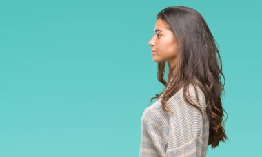 Genç güzel Arap kadın giyiyor kış kazak izole arka tarafına, seyir üzerinde dinlenmek doğal yüz emin gülümseme ile pozuyla profili.