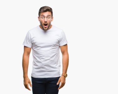 Korkuyor ve şok sürpriz ifade, korku ve heyecan yüz ile izole arka plan üzerinde gözlük takan genç yakışıklı adam.