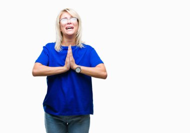 Yalvarıyor ve umut ifade yüzünde çok duygusal ve endişe ile birlikte elleriyle dua izole arka plan üzerinde gözlük takan genç güzel sarışın kadın. Bağışlanmak. Din kavramı.