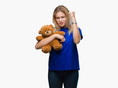 Sevimli Ayıcık izole tutan genç beyaz kadın arka plan ile öfke, çılgın ve yükseltilmiş eliyle diye bağıran rahatsız ve hayal kırıklığına uğramış öfke kavramı bağırarak