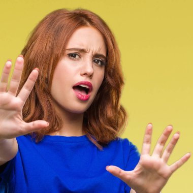 Şokta bağırarak genç güzel kadın izole arka plan korkuyor ve korku ifade dur hareketi el ile ile çok korkmuş. Panik kavramı.