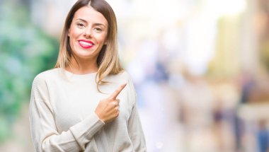 Genç güzel kadın rahat beyaz kazak izole arka neşeli bir gülümseme ile el ve parmak kadar kameraya bakarak yüzündeki mutlu ve doğal ifade ile yan ile işaret yüz üzerinden.