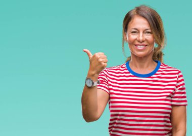 Orta yaş arıyor ve başparmak yanında yukarıyı mutlu yüz ile gülümseyen izole arka plan üzerine İspanyol kadın kıdemli.