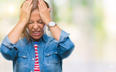 İspanyol kadın kıdemli orta yaş çünkü umutsuz ve stresli baş ağrısı acı izole arka plan üzerinde ağrı ve migren. Ellerini kafasına.