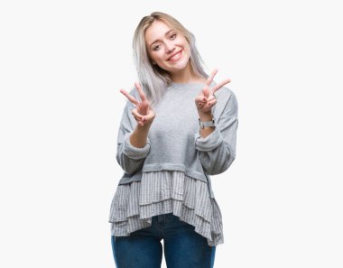 Genç Sarışın kadın parmaklarını zafer işareti yaparken gösterilen kamera seyir gülümseyen izole arka plan yüzünden. İki numaralı.