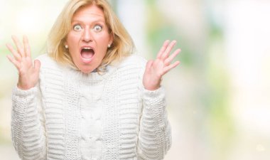 Orta yaş sarışın kadın üzerinde kış kazak giyen arka plan deli izole ve deli bağırarak ve agresif ifade ve silah kaldırdı bağırıyor. Hayal kırıklığı kavramı.