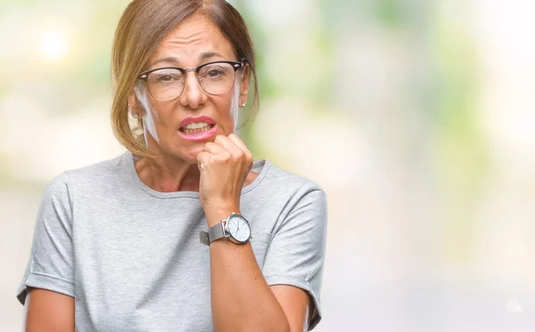 中年资深西班牙裔妇女戴着眼镜 在与世隔绝的背景下 手放在嘴上咬指甲时 神情紧张不安 焦虑问题 — 图库照片