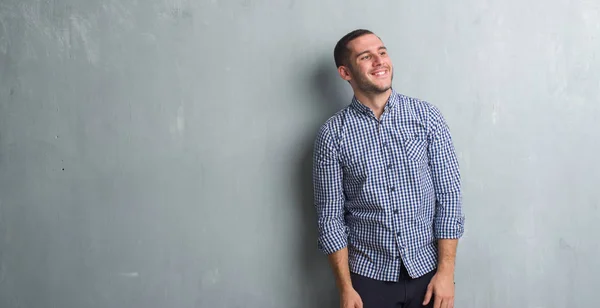 Joven Hombre Caucásico Sobre Pared Gris Grunge Mirando Hacia Otro — Foto de Stock