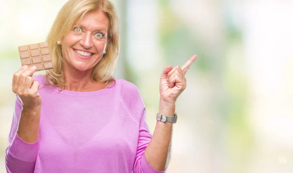 Mujer Rubia Mediana Edad Comiendo Barra Chocolate Sobre Fondo Aislado — Foto de Stock