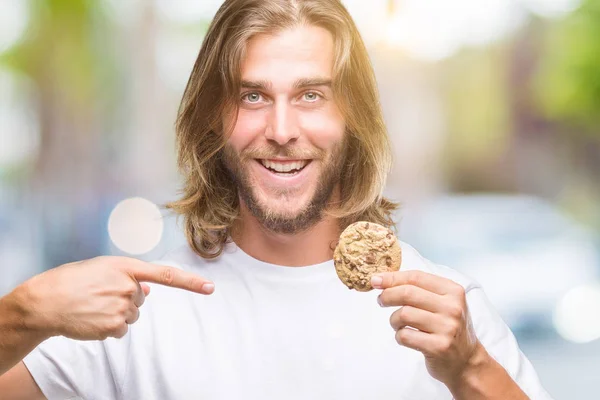 Junger Gutaussehender Mann Mit Langen Haaren Isst Schokoladenkeks Über Isoliertem — Stockfoto