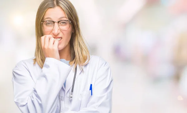 Young beautiful doctor woman headphones over isolated background looking stressed and nervous with hands on mouth biting nails. Anxiety problem.