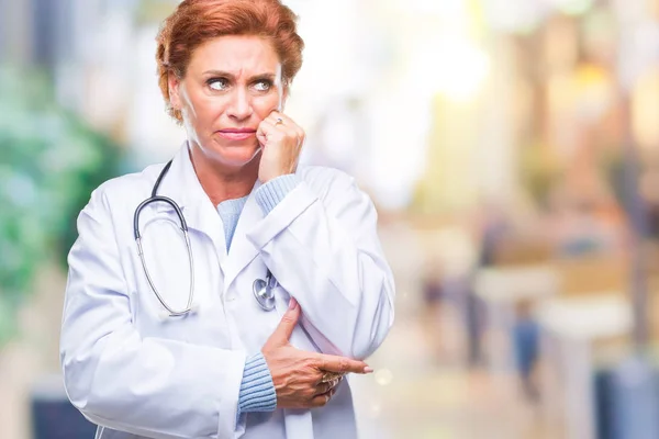 不安や両手の爪を噛んで口の中で緊張を探して孤立の背景に医療制服を着て先輩の白人医師女性 不安の問題 — ストック写真