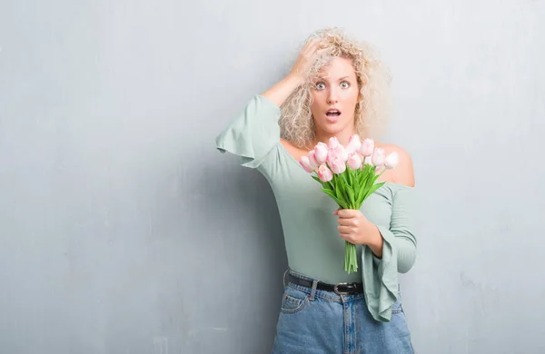 Jonge Blonde Vrouw Grijs Grunge Achtergrond Houden Van Bloemen Benadrukt — Stockfoto