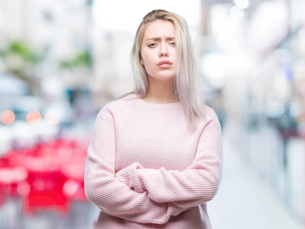 年轻的金发女人穿着冬季毛衣在孤立的背景怀疑和紧张 不赞成在脸上用交叉的武器表达 消极的人 — 图库照片