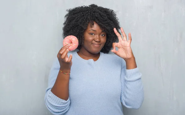 Junge Afrikanisch Amerikanische Frau Über Graue Grunge Wand Essen Rosa — Stockfoto