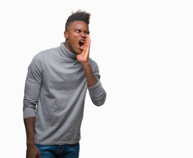 Afrikalı-Amerikalı genç bağırarak ve ağzı üzerinde el ile yan için çığlık izole arka plan üzerinde. İletişim kavramı.
