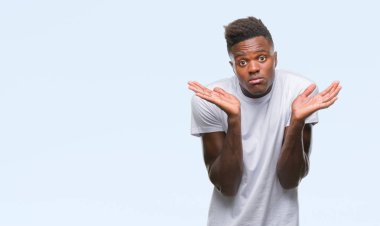 Afrikalı-Amerikalı genç izole arka plan clueless ve şaşkın bir ifadeyle kollar ve eller ortaya çıkar üzerinden. Şüphe kavramı.