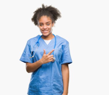 İzole arka neşeli bir gülümseme ile el ve parmak kadar kameraya bakarak yüzündeki mutlu ve doğal ifade ile yan ile işaret yüz genç afro Amerikalı doktor kadın.