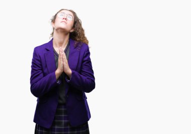 Genç esmer öğrenci kız yalvarıyor ve umut ifade yüzünde çok duygusal ve endişe ile birlikte elleriyle dua izole arka plan üzerinde okul üniforması ve gözlük takıyor. Bağışlanmak. Din kavramı.