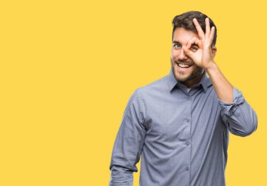 Genç yakışıklı adam gülümsüyor, parmakları ile mutlu yüz üzerinden seyir göz el ile ok jest yapıyor izole arka plan üzerinde.