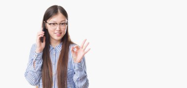 Parmak, mükemmel sembolü ile ok işareti yapıyor telefonda konuşan izole arka plan üzerinde Genç Çinli kadın