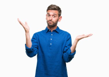 İzole arka plan clueless ve şaşkın bir ifadeyle kollar ve eller kaldırdı genç yakışıklı adam. Şüphe kavramı.