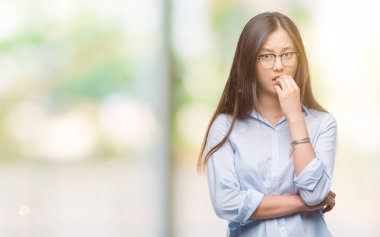 Stresli ve gergin elle çivi ısırma ağzına bakarak izole arka plan üzerinde gözlük takan genç Asya iş kadını. Anksiyete sorunu.