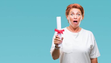 Derecesi sertifika izole arka plan üzerinde bir sürpriz yüz, korkuyor ve heyecanlı korku ifadesi ile şok korkmuş tutan kıdemli beyaz kadın