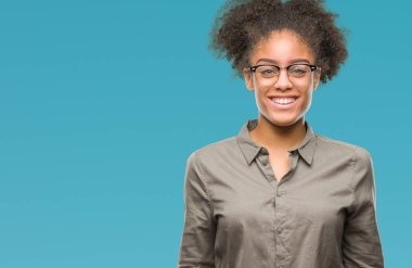Yüzünde mutlu ve güzel bir gülümseme ile izole arka plan üzerinde gözlük takan genç afro Amerikalı kadın. Şanslı kişi.