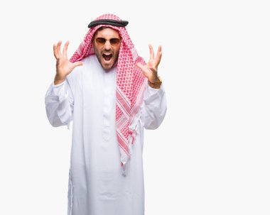 Yakışıklı delikanlı deli ve silah ile başarı için deli kutluyor izole arka plan üzerinde keffiyeh giyen kaldırdı ve heyecanlı çığlık gözler kapalı. Kazanan kavramı