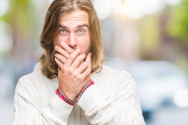 Uzun saçlı üzerinde kış kazak giyen genç yakışıklı adam arka plan ağız hata için elleriyle kapsayan şok izole. Gizli kavramı.