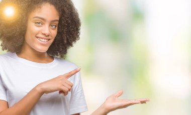 Genç afro Amerikalı kadın üzerinden hayran ve el ile sunulması ve parmak ile işaret ederken kameraya gülümseyen izole arka plan.