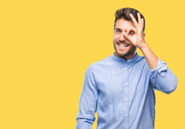 Genç yakışıklı adam gülümsüyor, parmakları ile mutlu yüz üzerinden seyir göz el ile ok jest yapıyor izole arka plan üzerinde.