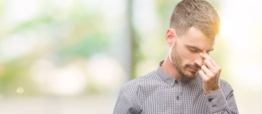 Genç hipster adam burun ve göz yorgunluğu ve baş ağrısı duygu sürtünme yorgun. Stres ve hayal kırıklığı kavramı.