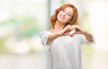 Genç güzel kadın kalp simgesi ve elleriyle şekil gösterilen aşık gülümseyen izole arka plan yüzünden. Romantik kavramı.