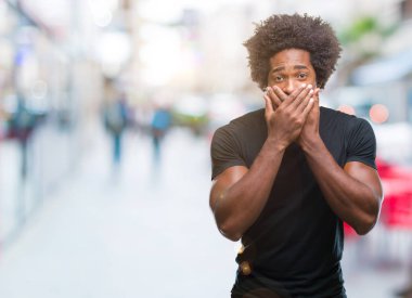 İzole arka plan ağız hata için elleriyle kapsayan şok Afro Amerikan adam. Gizli kavramı.