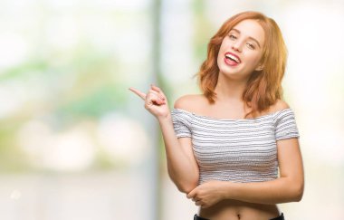 Kameraya bakarak yan el ve parmak ile işaret izole arka yüzünde kocaman bir gülümseme ile genç güzel kadın.