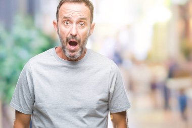 Orta yaş üst düzey ağarmış adam izole arka plan korkuyor ve sürpriz ifade ile şok korku ve yüz heyecanlı.