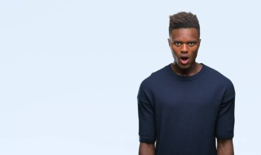 Genç Afro-Amerikan adam korkuyor ve şok sürpriz ifade ile izole arka plan üzerinde korku ve yüz heyecanlı.