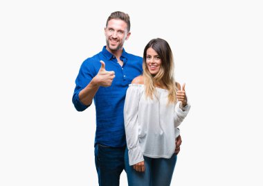 Genç çift hareketi el ile mutlu yaşasın yapıyor izole arka plan üzerinde aşık. Kameraya bakarak başarı gösteren ile ifade onaylama.